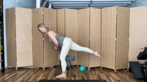 Woman doing Pilates exercises standing with a chair extending one leg for fitness strength and balance