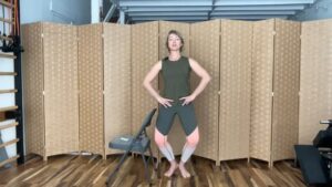 Woman doing standing Pilates exercises with a chair for fitness and strength