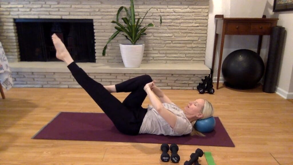 Woman doing Pillates exercises on the Pilates mat.