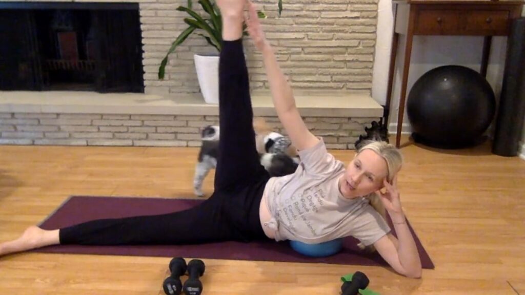 Woman doing Pilates on her Pilates mat lying on her side.