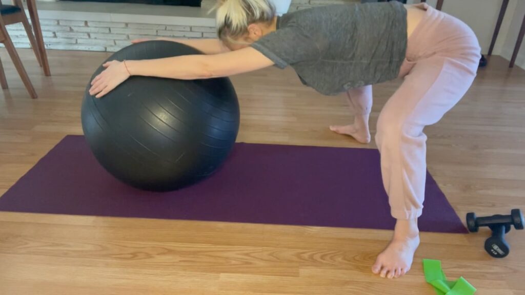 Woman doing Pilates squats with a ball.