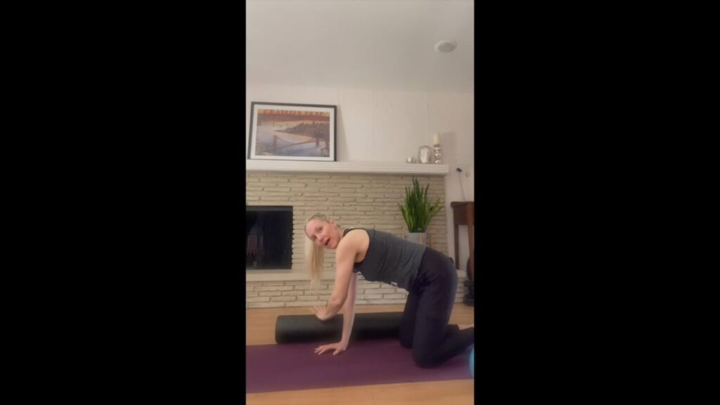 Woman doing pilates with the foam roller.