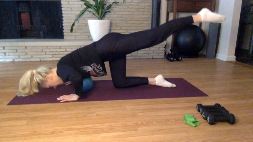 woman doing pushups on a pilates mat