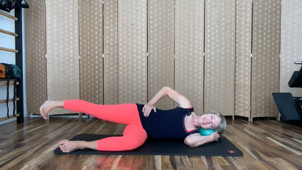 Woman doing Pilates hip strengthening exercises on the mat