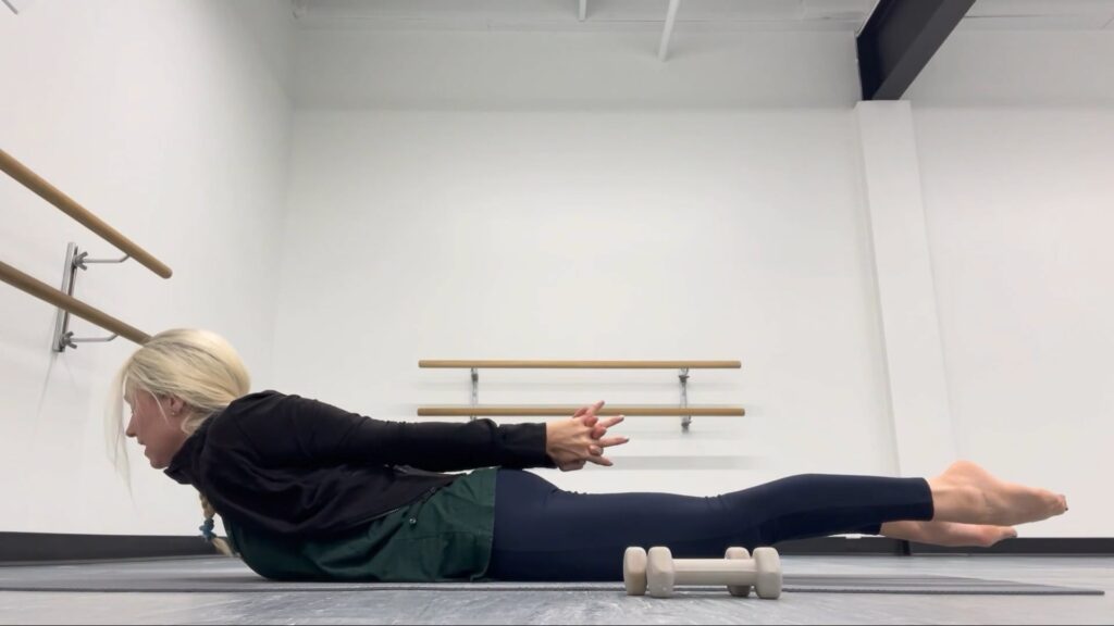 Woman doing Pilates in a dance studio.