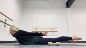 Woman doing Pilates in a dance studio.