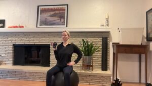 Woman doing Pilates with weights on a ball