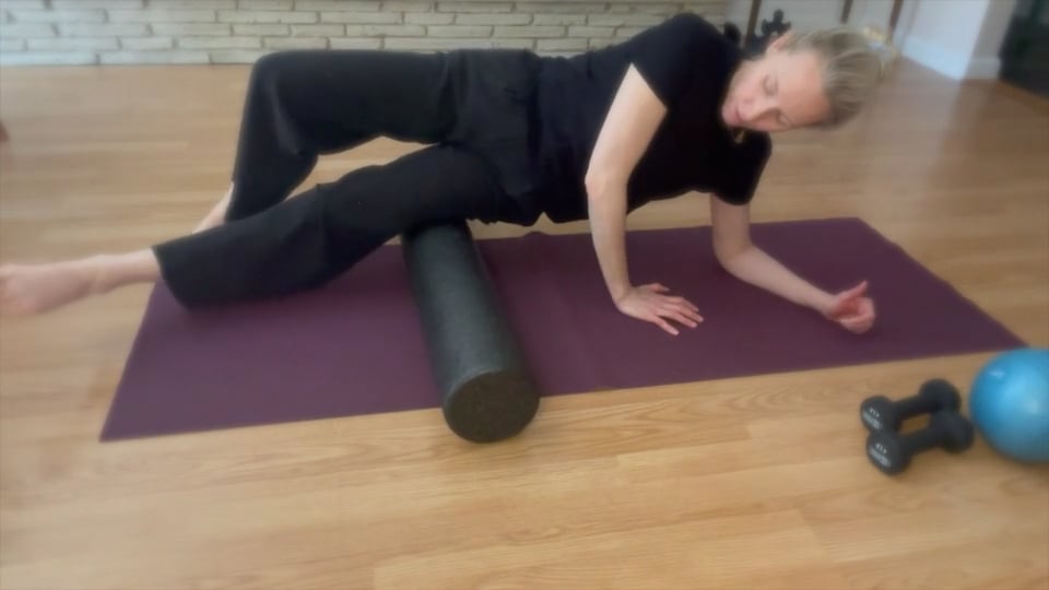 Woman on Pilates foam roller rolling IT Band