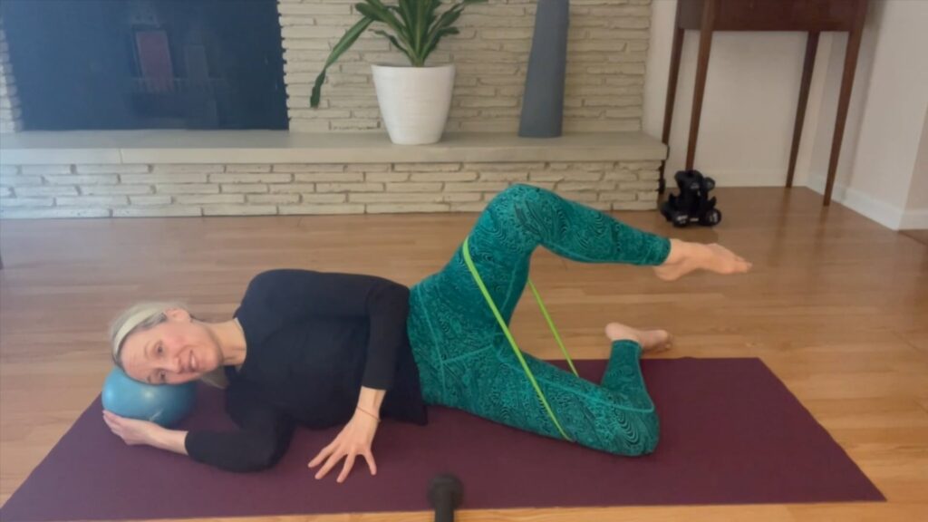 woman doing sidelying pilates exercises on a pilates mat.