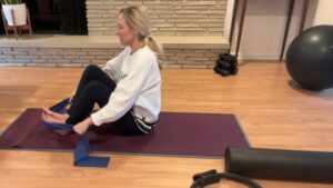 woman doing pilates with a theraband on her feet