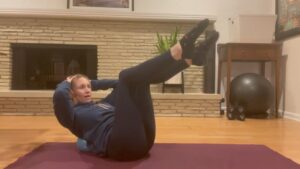 Woman doing Pilates ab work with blue ball