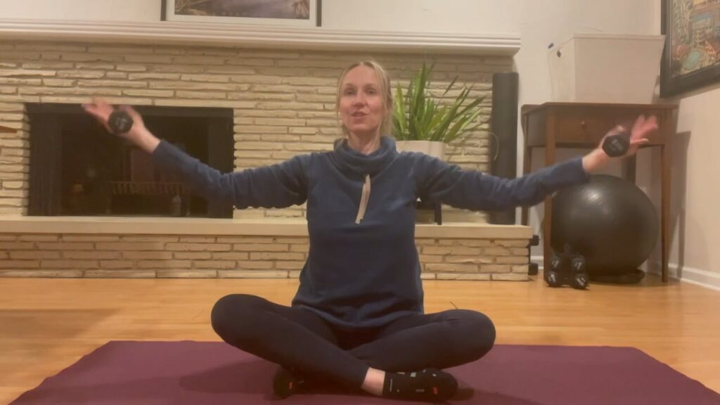 woman doing pilates exercises sitting up on a mat